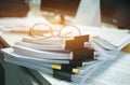 Glasses placed on Unfinished documents stacks of paper files on computer desk for report , piles of unfinished papers achieves Royalty Free Stock Photo