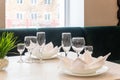 Glasses, plates, napkins served for dinner in restaurant with cozy interior Royalty Free Stock Photo