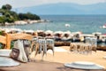 Glasses and plates on a wooden table of a greek tavern over the view of the port of Amaliapoli, Greece