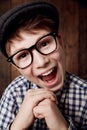 Glasses, portrait and happy for boy in funny comic and vintage fashion in eyewear by wooden background. Child, face or Royalty Free Stock Photo