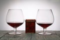 Glasses with red dry wine. Gift in a box. Stand on wooden boards. Shot in backlight Royalty Free Stock Photo