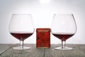 Glasses with red dry wine. Gift in a box. Stand on wooden boards. Shot in backlight Royalty Free Stock Photo