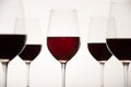 Glasses with red grape wine and bottle on a white glossy surface Royalty Free Stock Photo