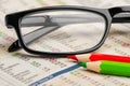 Glasses red green pen pencil on newspaper with stock market exchange data chart finance business concept background Royalty Free Stock Photo