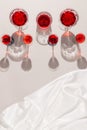 Glasses with red juice or wine on pastel beige background with shades and white silk cloth. Summer drinks and refreshment concept Royalty Free Stock Photo