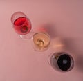 Glasses of red, rose and white wine on pink background, flat lay Royalty Free Stock Photo