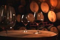 Glasses of red wine on background of wooden oak barrels in cellar of winery Royalty Free Stock Photo