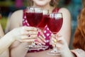 Glasses of red wine in female hands. Toast at a party. The concept of alcohol, holiday