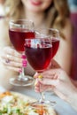 Glasses of red wine in female hands. Toast at a party. Vertical. Concept of alcohol, holiday Royalty Free Stock Photo