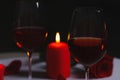 Glasses of red wine, rose flower and burning candle on table. Romantic atmosphere Royalty Free Stock Photo