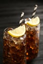 Glasses of refreshing soda water with ice cubes and lemon slices on black table, closeup Royalty Free Stock Photo