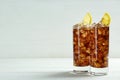 Glasses of refreshing soda water with ice cubes and lemon slices on white wooden table, space for text Royalty Free Stock Photo