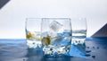 Glasses of refreshing water with ice and lemon on a blue background. Heat concept, fresh. Natural light, copy space Royalty Free Stock Photo