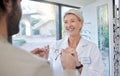 Glasses, retail shop and vision of a senior eye doctor holding a frame to help customer shopping. Happy optometrist