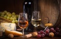 Glasses of rose and white wine cheeses grapesand barrel brown background Royalty Free Stock Photo