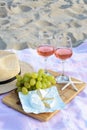 Glasses with rose wine and snacks for beach picnic on sand outdoors Royalty Free Stock Photo