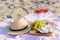 Glasses with rose wine and snacks for beach picnic on sand outdoors Royalty Free Stock Photo