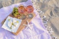 Glasses with rose wine and snacks for beach picnic on sand outdoors Royalty Free Stock Photo