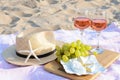 Glasses with rose wine and snacks for beach picnic on sand outdoors Royalty Free Stock Photo
