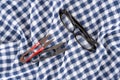 Glasses and scissors on blue and white plaid fabric Royalty Free Stock Photo