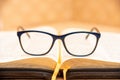 Glasses for sight lie on the Bible, the Bible in leather black cover with tabs lies on the table Royalty Free Stock Photo