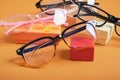 Glasses on a small rted gift box, small gift boxes and different frames for glasses on a brown background copy space Royalty Free Stock Photo