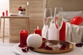 Glasses of sparkling wine, candles and petals on white table indoors. happy Valentine`s Day Royalty Free Stock Photo