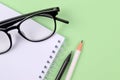 Glasses, spring-loaded notebook, white and black pencils Royalty Free Stock Photo