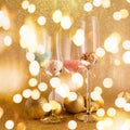 Glasses with sprinkles and toys on the festive golden background. Christmas and New Year party concept. Stylish trendy Royalty Free Stock Photo