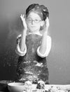 glasses standing near table with colorful bowls, tasty cakes, rolling pin and playing with flour on red studio