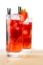 Glasses of strawberry cocktail with ice on light wood table Royalty Free Stock Photo