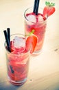 Glasses of strawberry cocktail with ice on old wood table, old style Royalty Free Stock Photo