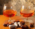 Glasses of strong alcoholic drink cognac and sweets on the table.