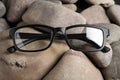 Glasses in stylish black frame on stones, closeup Royalty Free Stock Photo