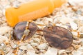 Glasses, sunscreen cream and beads on shells Royalty Free Stock Photo