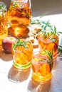 Glasses of sweet peach iced tea, Summer cold peach fizz cocktail with rosemary. Sunny light. Shallow depth of the field, close up Royalty Free Stock Photo