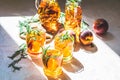 Glasses of sweet peach iced tea, Summer cold peach fizz cocktail with rosemary. Sunny light. Shallow depth of the field, close up Royalty Free Stock Photo