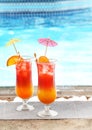 Glasses with tasty cocktails near pool
