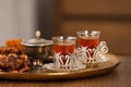 Glasses with tasty Turkish tea and oriental sweets on wooden table indoors, space for text