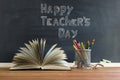 Glasses teacher books and a stand with pencils on the table, on the background of a blackboard with chalk. The concept of the Royalty Free Stock Photo