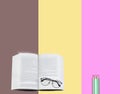 Glasses on text book and pencils on brown, yellow and pink background. Royalty Free Stock Photo