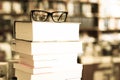 Glasses on top of different books lying on table in school library Royalty Free Stock Photo