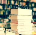 Glasses on top of stack of books lying on table in bookstore