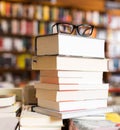 Glasses on top of stack of books lying on table in bookstore Royalty Free Stock Photo