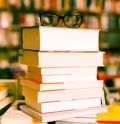 Glasses on top of stack of books lying on table in bookstore Royalty Free Stock Photo