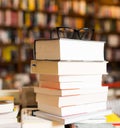 Glasses on top of stack of books lying on table in bookstore Royalty Free Stock Photo