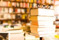 Glasses on top of stack of books lying on table in bookstore