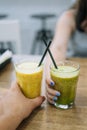 Glasses with vegetable and fruit smoothie. Man and woman holding glasses with spinach and smoothie Royalty Free Stock Photo