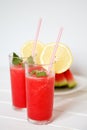 Glasses of watermelon smoothie and heartshapes on rustic wooden background