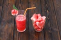 Glasses of watermelon smoothie and heartshapes on wooden background